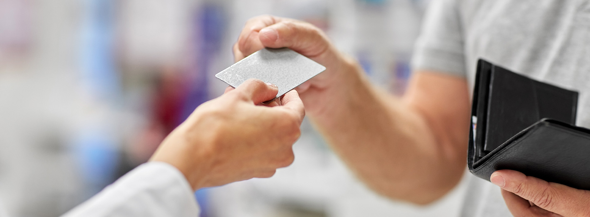 medicine payment and finance people concept close up of hand giving bank card to pharmacist