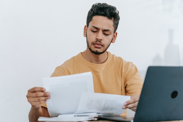 man looking at documents and computer