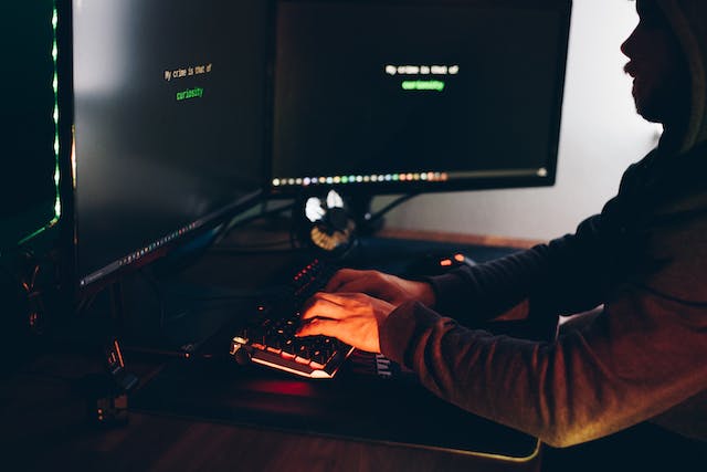 man sitting in dark at computers