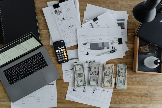 paper, money, computer on desk