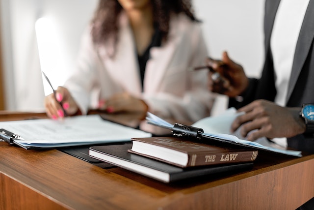 two people sitting at table with books