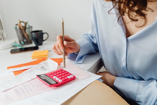 woman looking at documents with calculator